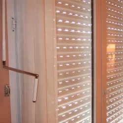 Blinds and light switch on window with crank operated shutters