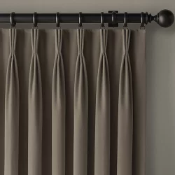 A wall-mounted curtain with pleated drapes