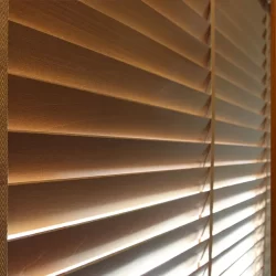 A window with open wooden blinds, allowing sunlight to enter the room