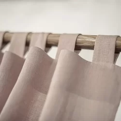 A stylish pink fabric curtain with tab top