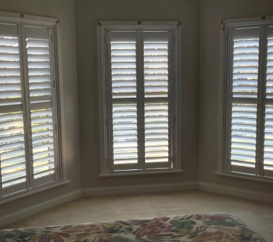 3 white custom plantations shutters fixed in the bedroom